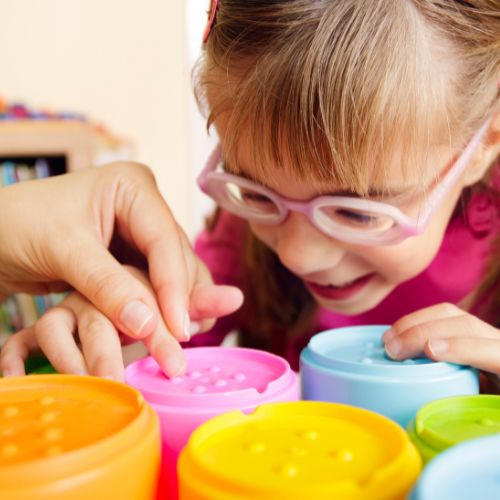 A young student playing with sensory objects